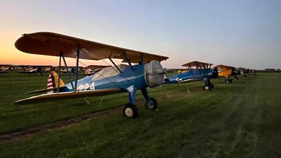 A row of historic planes on a grass field at the Tri-State Warbird Museum along the Lewis and Clark Historic Trail